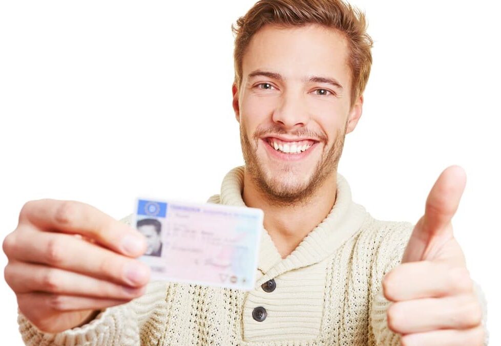 Happy man with his motorcycle license holding his thumbs up